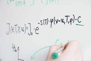 Whiteboard mit einem gezeichnet Diagramm. Daneben wurden zwei Formeln geschrieben. Darunter hält eine Hand einen Stift und zeichnet ein Diagramm.