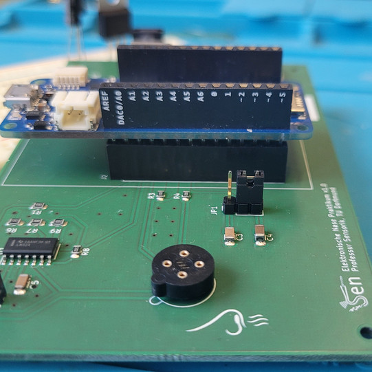PCB Platine mit einem nicht besetzten Steckplatz für einen Sensor. Daneben ist auf der Platine eine Nase aufgedruckt. Weiterhinten auf der Platine ist ein kleines Arduinoboard eingesteckt.